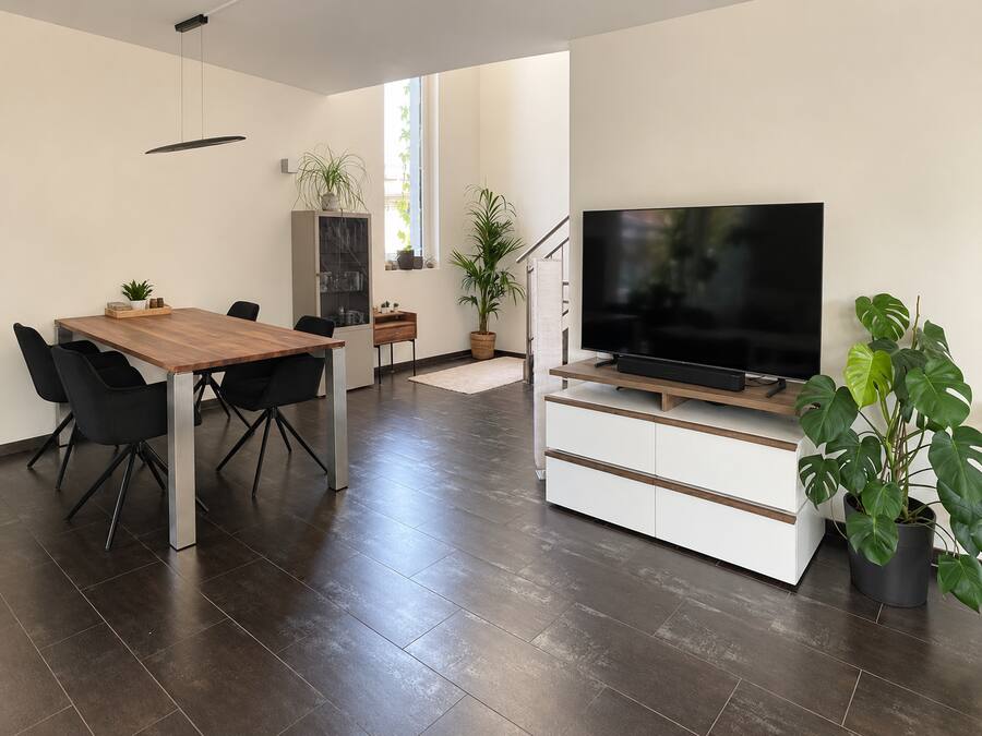 Wohnzimmer nach der Umgestaltung mit Essbereich, TV-Zone und Pflanzen